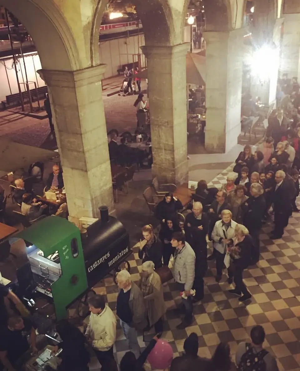 Cua de gent davant la locomotora, sota les voltes de la plaça de la Independència, vista des de dalt